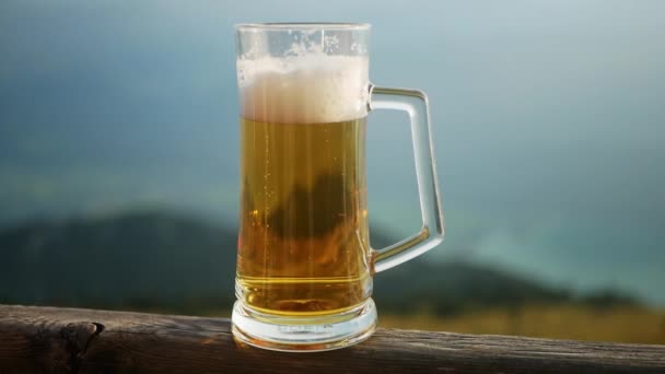 Склянка холодного пива на відкритому повітрі на дерев'яному паркані
 - Кадри, відео