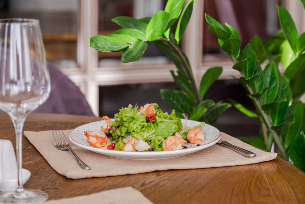 light healthy salad of fresh vegetables and shrimp. Photo in the interior - Fotoğraf, Görsel