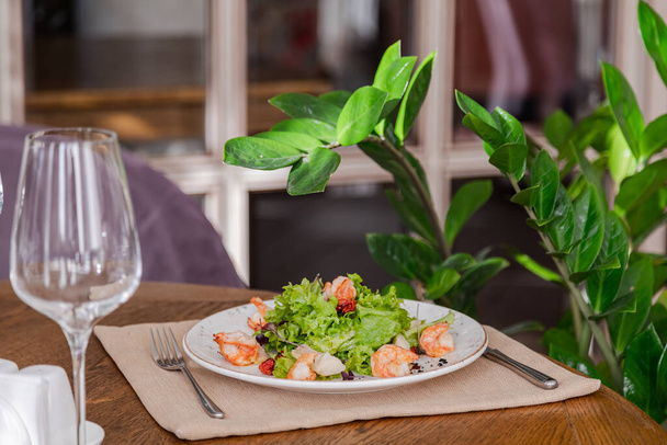 light healthy salad of fresh vegetables and shrimp. Photo in the interior - Zdjęcie, obraz
