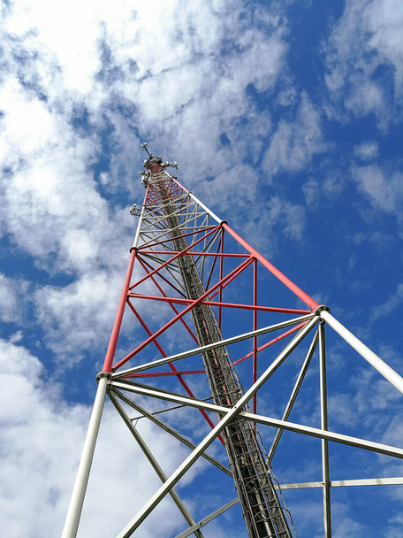Ana istasyon ve mavi bulutlu gökyüzünün önündeki tekrarlayıcı kule (Global System for Mobile communication) - Fotoğraf, Görsel