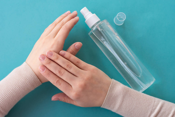 Top view of young girls hands using spray bottle with antiseptic liquid. Concept of health care, self-hygiene and prevention of coronavirus spreading - Foto, afbeelding