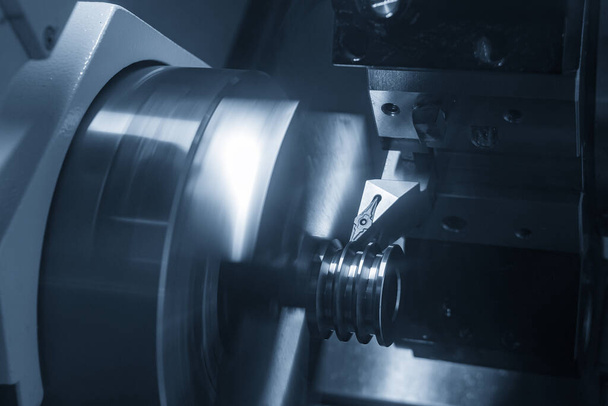 La scanalatura della macchina tornio CNC taglia le parti della puleggia metallica con effetto luce. La lavorazione dei metalli ad alta tecnologia mediante tornitura CNC
 . - Foto, immagini