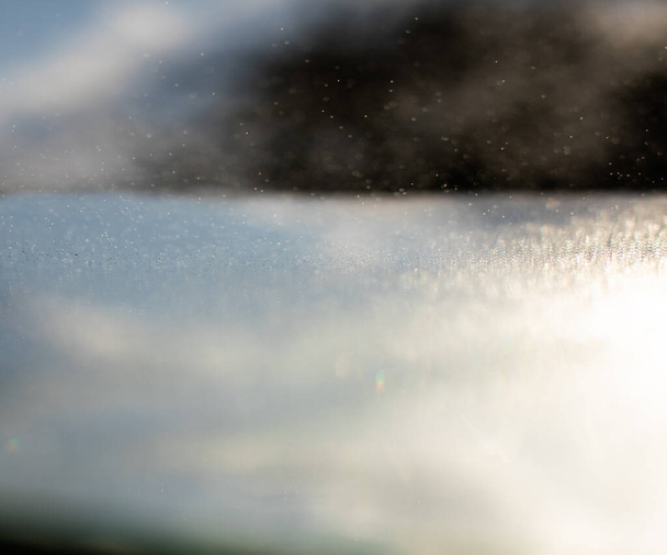 Kleine druppels water geslagen door de zon in de tegenjour vorm grijze abstracties - Foto, afbeelding