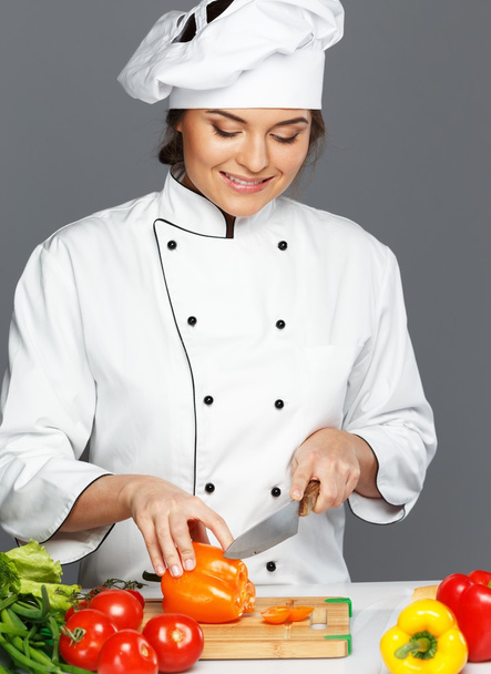 Beautiful young woman cook cutting fresh paprika - Foto, imagen
