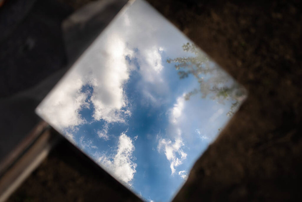 Yerdeki bir aynada yansıyan bulutlu gökyüzü - Fotoğraf, Görsel