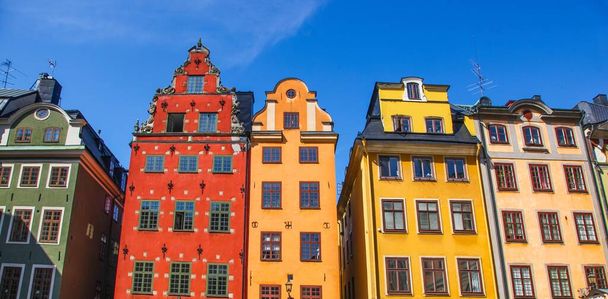Иконические красные, зеленые и желтые исторические здания Старого города Гамла Стан в Стокгольме, Швеция
 - Фото, изображение