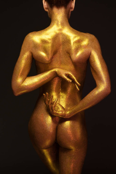 sexy girl gold-plated glittering posing - Photo, Image