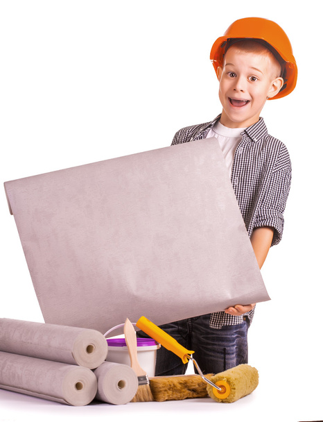 Kid with a rolls of wallpaper and brush. isolated - Foto, imagen
