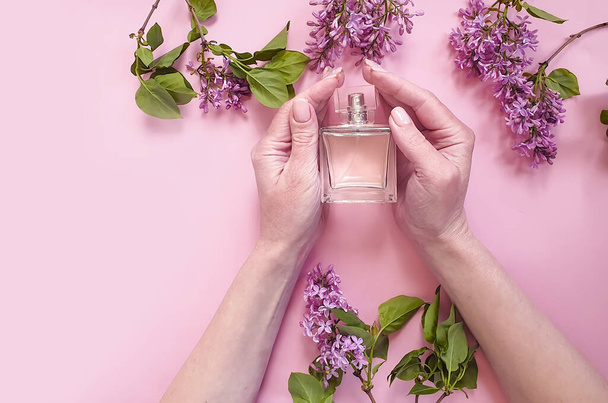 Weibliche Hände halten Parfüm, Blume Flieder - Foto, Bild