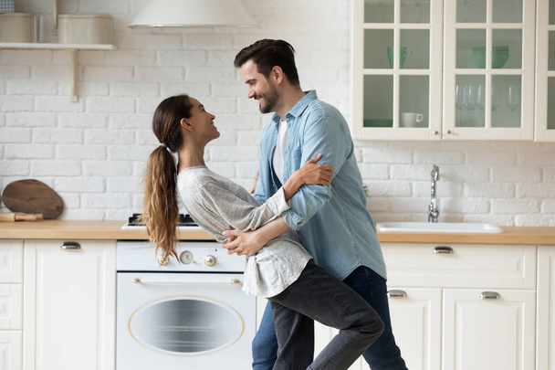 Happy couple have fun dancing in modern kitchen together - Fotoğraf, Görsel