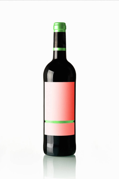 Botella de vino tinto con etiqueta vacía sobre fondo blanco
 - Foto, imagen