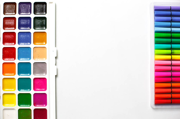 A palette of color watercolors with brushes and markers on a white background with space for text. Creative classes with children at home and at school, art master class, the concept of creative development. Desktop of the creative workshop-flatlay - Foto, Imagem