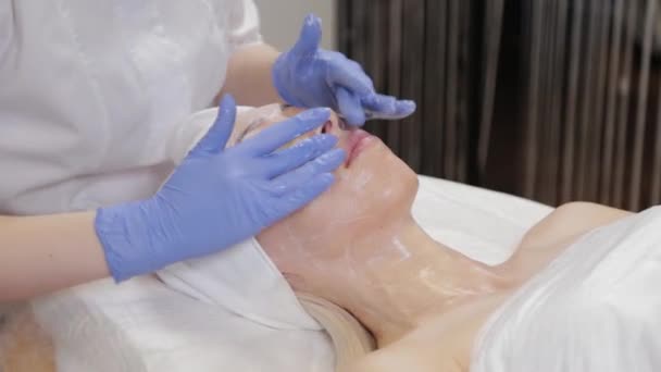 Un esteticista profesional le hace masajes faciales a una mujer. Cosmetología
. - Imágenes, Vídeo