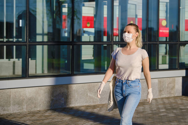 European blond woman in protective mask and gloves walking outdoors - Foto, imagen