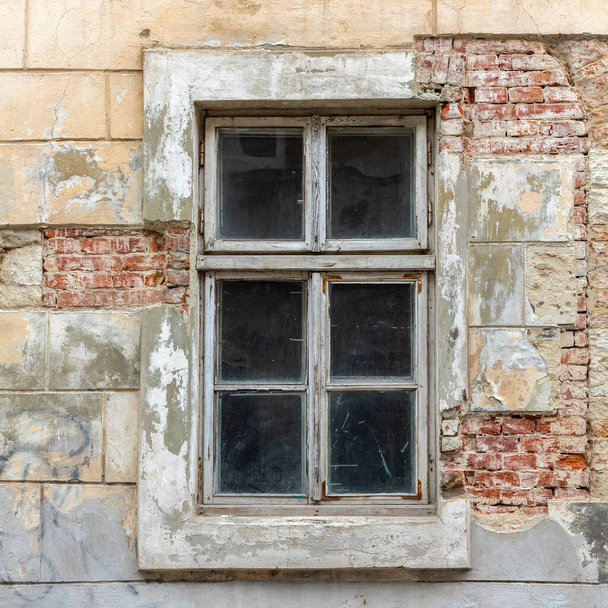 Old vintage window in a white wooden frame on a grunge damaged wall. - Valokuva, kuva