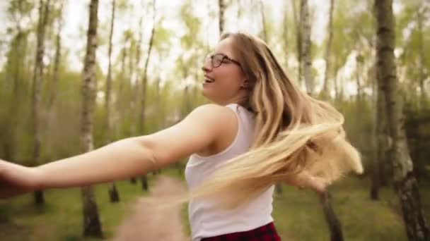 Piękna młoda, szczęśliwa, biała kobieta kręcąca się w lesie. Koncepcja wolności - Materiał filmowy, wideo