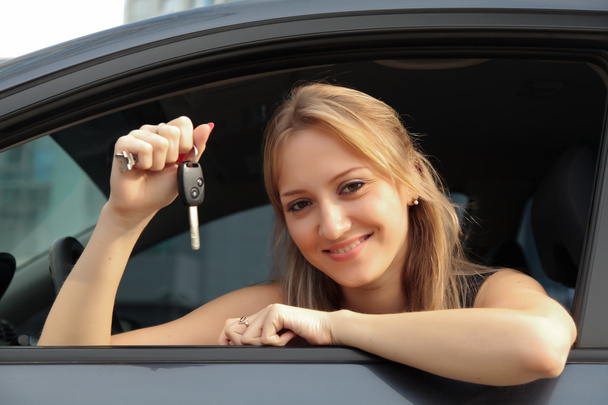 The happy woman showing the key of her new car - Foto, Bild