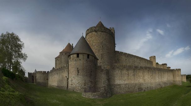 French castle from the 12th century on a cloudy day next to the lawn - Photo, Image