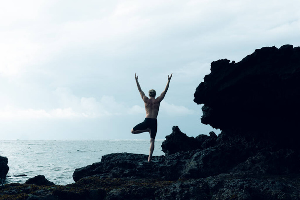 Athlete man practicing yoga outdoors photograph - Foto, Imagem