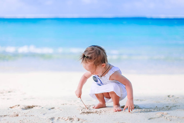 Little girl at tropical white beach making sand castle - Foto, Imagen