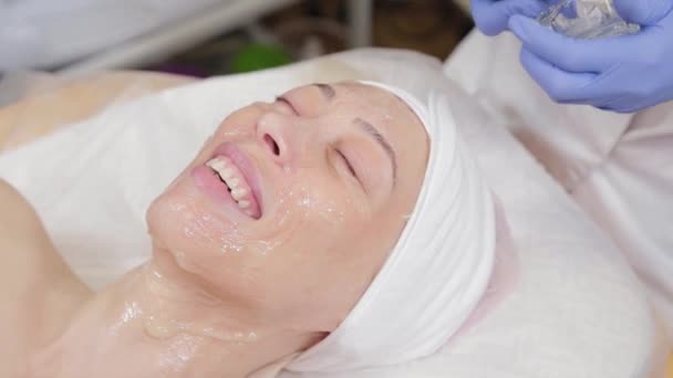 Professionelle Kosmetikerin trägt einer Frau eine Gesichtsmaske auf. - Filmmaterial, Video