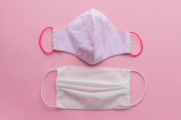 Zero waste during coronavirus outbreak. Choose reusable textile face mask. Single use mask and reusable face mask on pink background flat lay. Disposable and handmade textile mask - Foto, Imagen