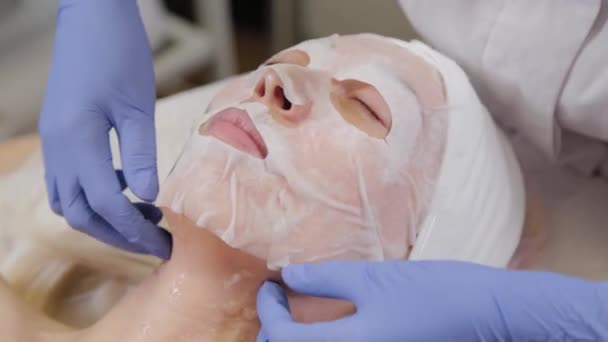 Profesyonel kadın müşteriye yüz maskesi takar. Kozmetoloji. - Video, Çekim