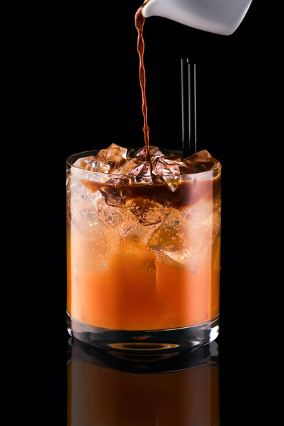 Pouring espresso in glass with tonic and ice isolated on black background - Φωτογραφία, εικόνα