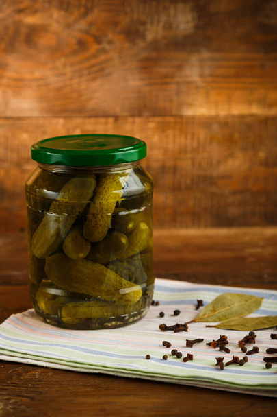 Jars of pickled homemade pickles on a linen towel on a wooden table. - Photo, Image