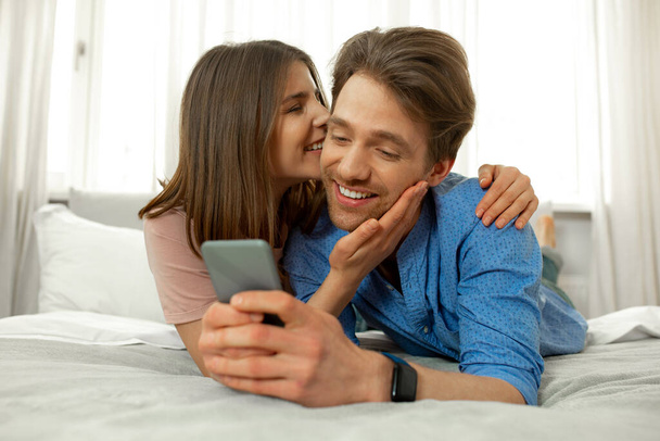 Male and female reading news on smartphone - Foto, Imagem