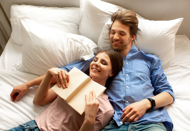 Smiling male and female reading a book - Foto, immagini