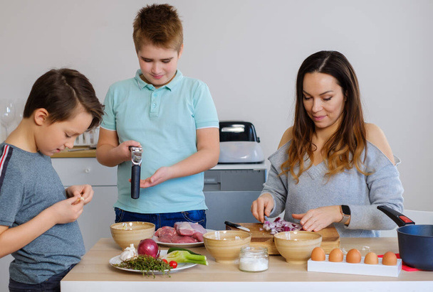Happy family cooking togehter at home. - Foto, afbeelding