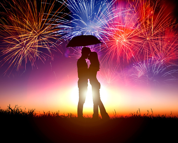 Couple kissing under umbrella with firework in the sky - Photo, Image