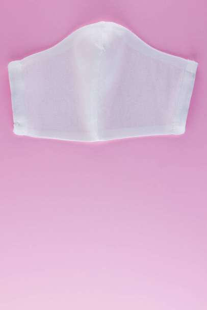 Protective gauze mask on a pink background. White antivirus mask. Handmade medical protective mask from cotton. Protective face mask made of gauze. Top view. Copy spac - Fotó, kép