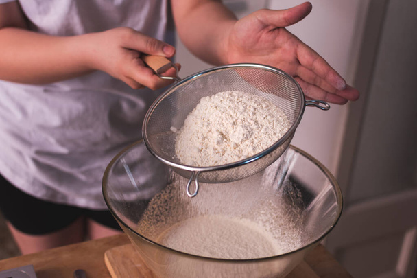 osoba przesiewania mąki w kuchni - Zdjęcie, obraz
