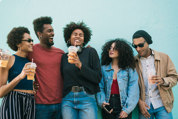 Portrait of afro friends having fun together and enjoying good time while drinking fresh fruit juice.  - Zdjęcie, obraz