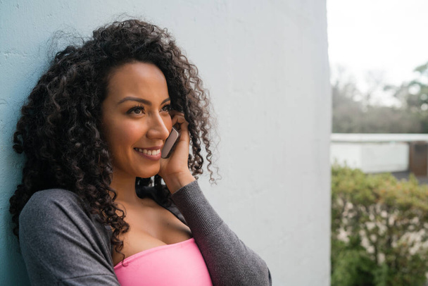 Portrait d'une jeune femme latino-américaine afro-américaine parlant au téléphone. Concept de communication. - Photo, image