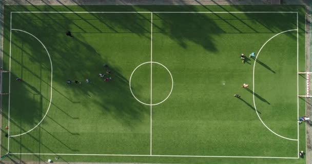 Вид с воздуха на зеленый футбол или футбольное поле, где подростки играют в футбол в солнечный летний день.
 - Кадры, видео