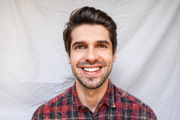 Portrait of a young handsome guy with a wide open smile in a shirt - Foto, imagen