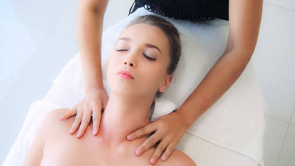 Femme détendue se faisant masser les épaules dans un spa de luxe par un massothérapeute professionnel. Concept de bien-être, guérison et relaxation. - Photo, image