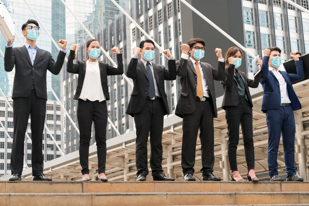 Pessoas de negócios confiantes com máscara facial protegem de Coronavirus ou COVID-19. Conceito de ajuda, apoio e colaboração para superar a epidemia de Coronavirus ou COVID-19 para reabrir os negócios
. - Foto, Imagem