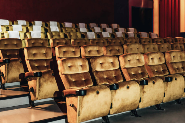 A row of yellow seat with popcorn on chair in the movie theater - Photo, Image