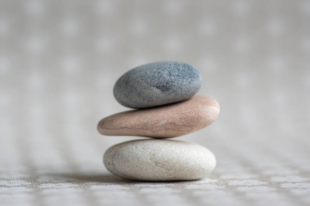 Stone cairn on striped grey white background, three stones tower, simple poise stones, simplicity harmony and balance, rock zen sculpture - Φωτογραφία, εικόνα