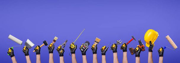Workers hands with different tools on empty purple background - Fotografie, Obrázek