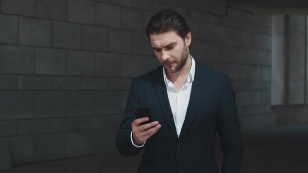 Geschäftsmann mit Smartphone auf der Straße. Manager SMS auf dem Handy in der Stadt - Filmmaterial, Video