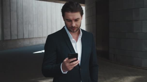Businessman using smartphone outside. Worker browsing internet online on street - Materiał filmowy, wideo