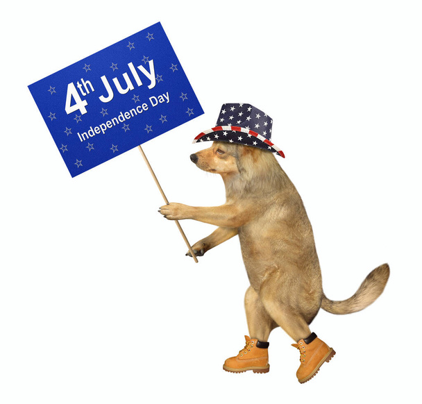 Бежевый собачий патриот идет с табличкой, на которой написано 4 июля День Независимости. Белый фон. Isolated
. - Фото, изображение
