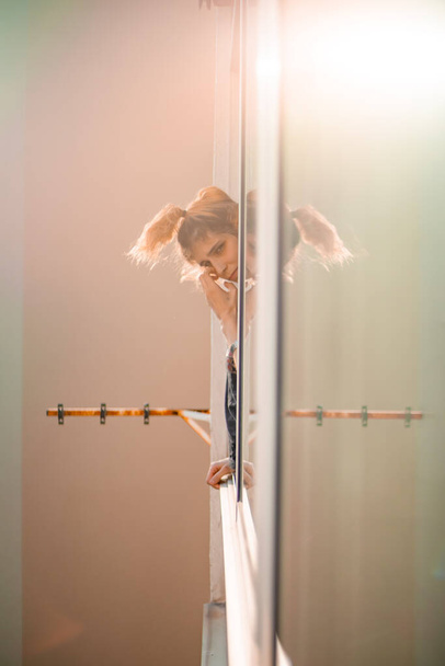 Menina loira na janela em quarentena refletida enquanto a pandemia do vírus corona
 - Foto, Imagem