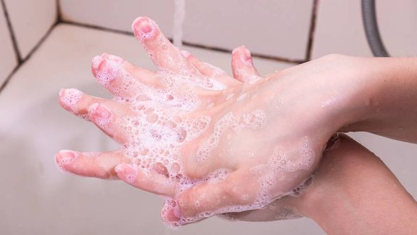 Femme se lave les mains avec du savon liquide, de la mousse de savon, gros plan
 - Photo, image