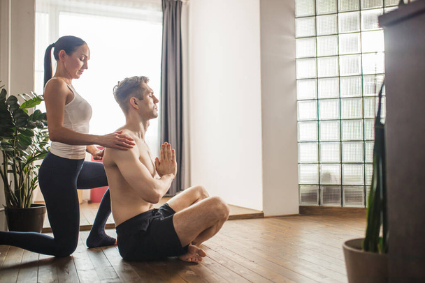 wife help her husband to take the right position in yoga - Φωτογραφία, εικόνα